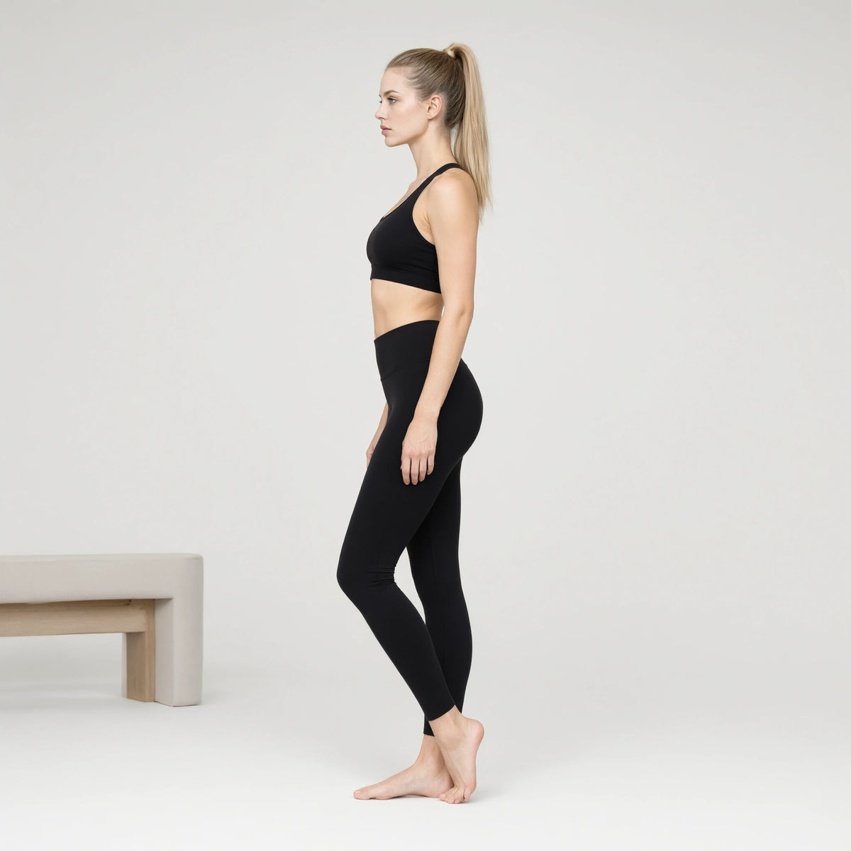 Black | Professional Sports Seamless Bra｜DUVETMOON – side view (ankles gently crossed)