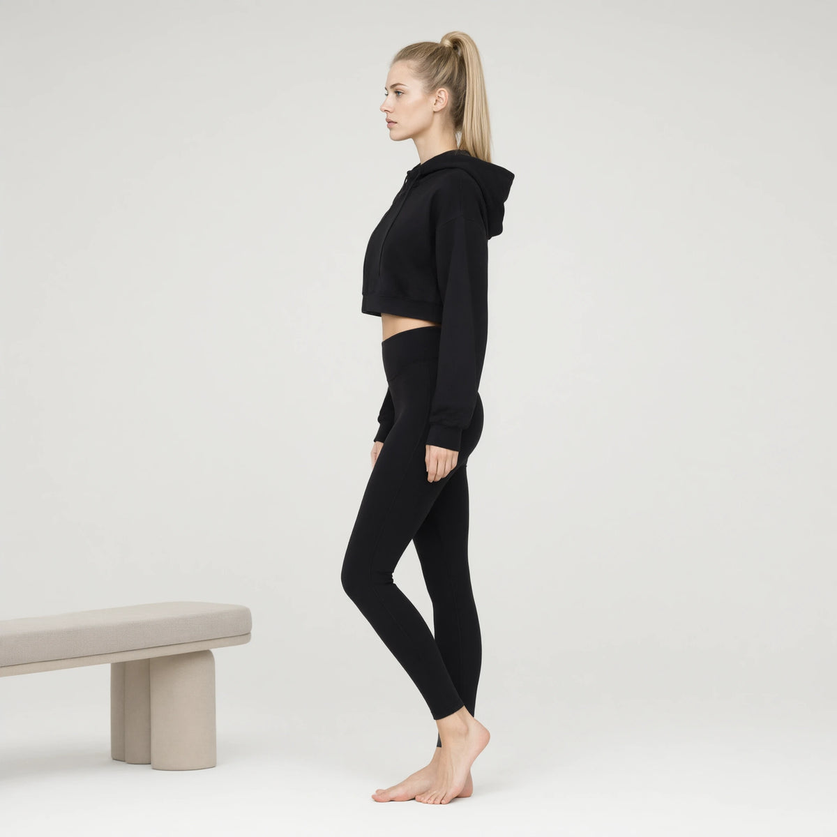 Black | Crop-top Yoga Workout Short Hoodie｜DUVETMOON – side view (ankles gently crossed)