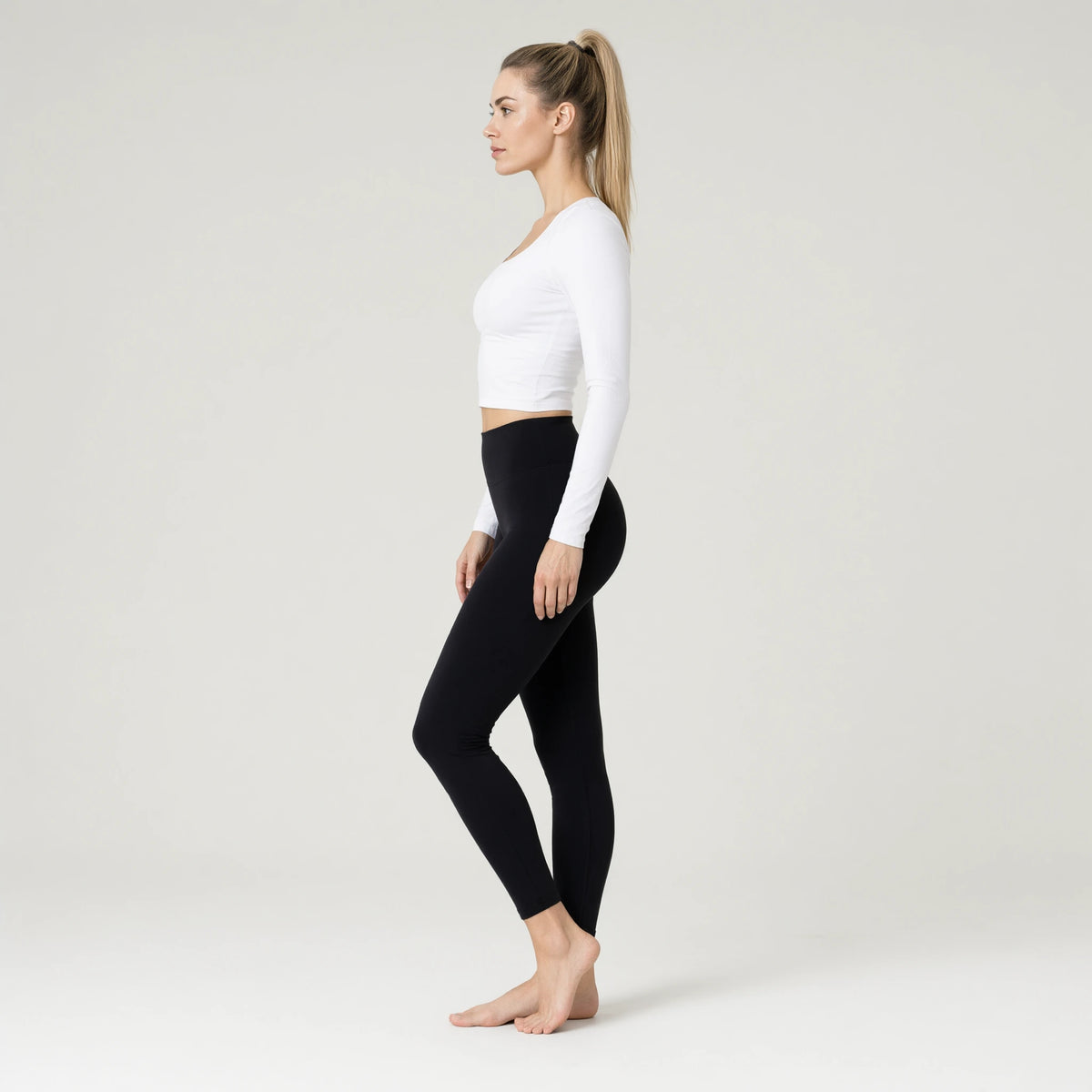White | Long Sleeve Yoga Wear Outdoor Sports Top｜DUVETMOON – side view (ankles gently crossed)