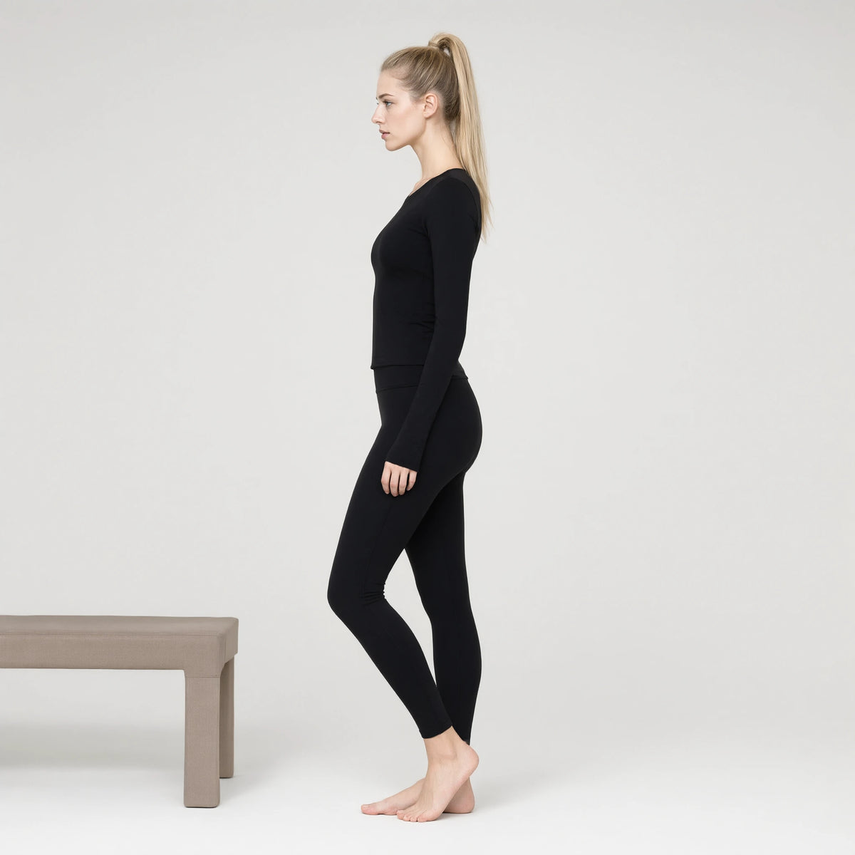 Black | Running Long Sleeve Slim T-shirt Yoga Top｜DUVETMOON – side view (ankles gently crossed)