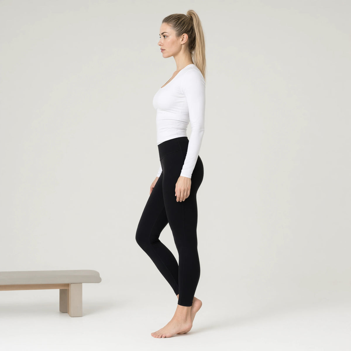 White | Long Sleeve Yoga Top｜DUVETMOON – side view (ankles gently crossed)