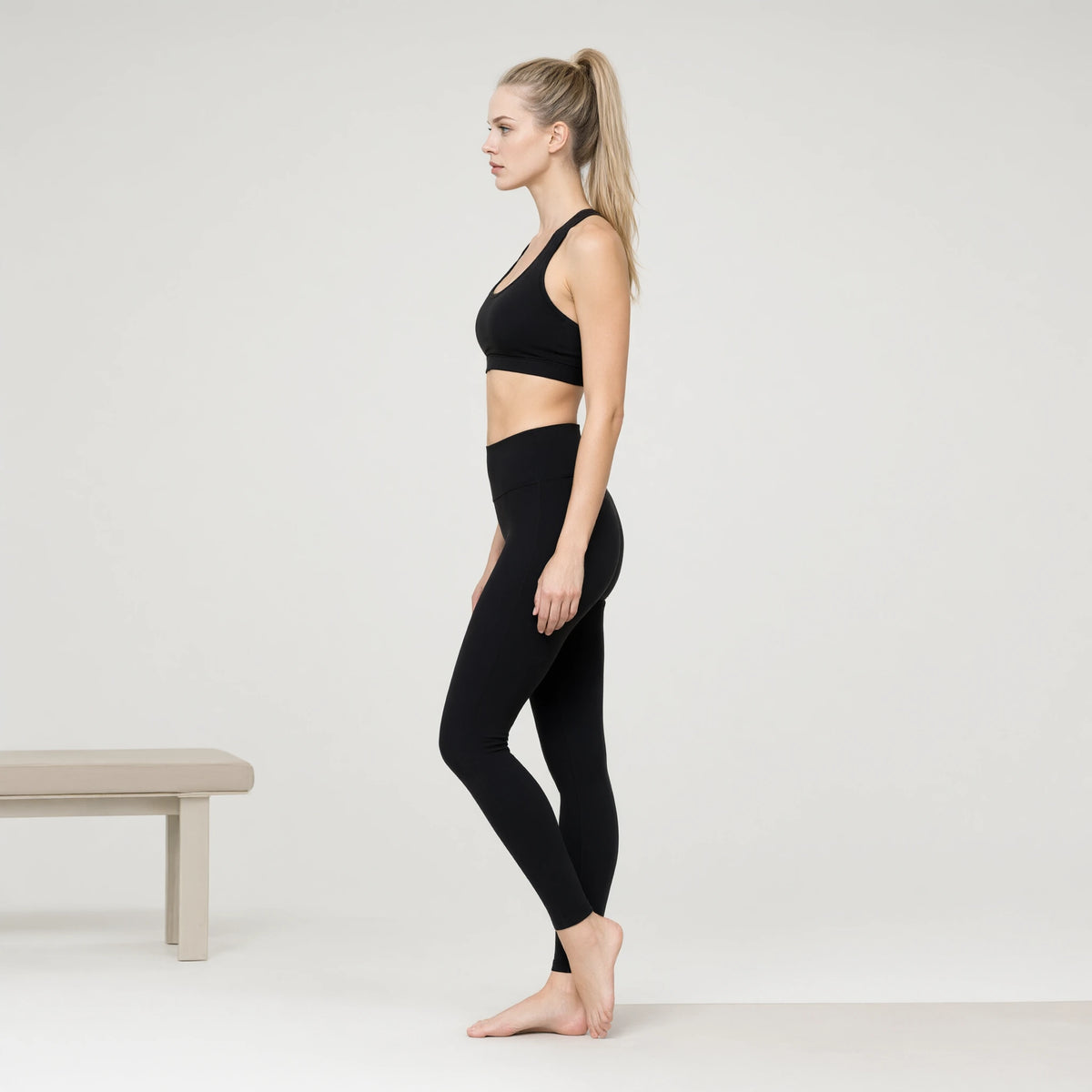 Black | Padded Yoga Vest Tight Waist Length Tank Top｜DUVETMOON – side view (ankles gently crossed)