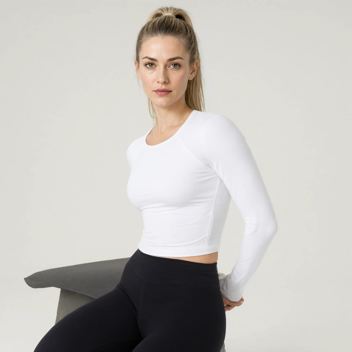 White | Long Sleeve Yoga Top｜DUVETMOON – detail close-up (hands clasped behind the back)